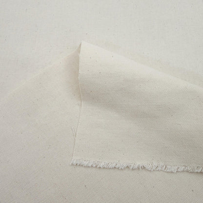 a close-up view of a piece of white fabric, possibly cotton, with a fringed edge.