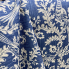 Blue and cream botanical fabric with floral vine pattern draped to show texture and detail