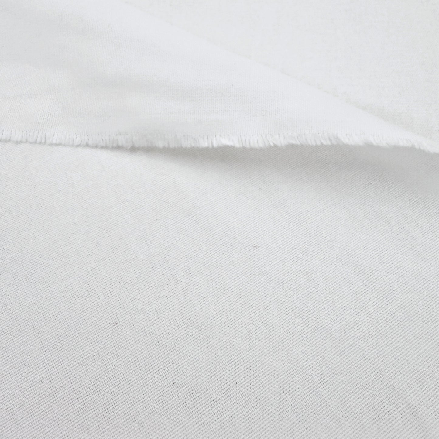 A close-up view of a white fabric, possibly cotton, with a slightly wrinkled texture.