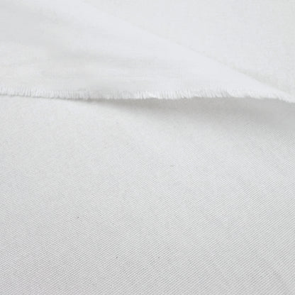 A close-up view of a white fabric, possibly cotton, with a slightly wrinkled texture.