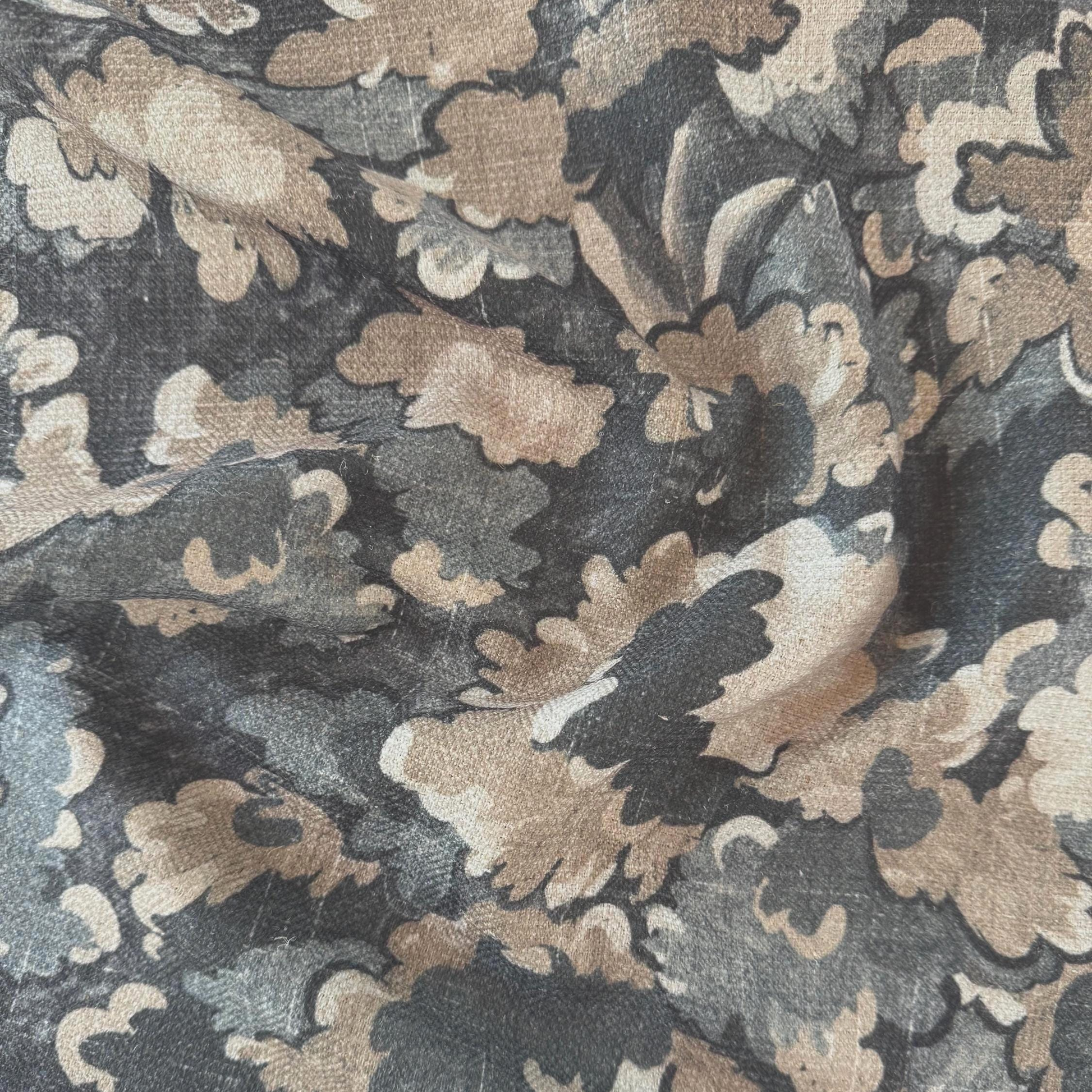 The image is a close-up of a fabric with a floral pattern in shades of brown and gray. The pattern consists of various shades of brown and gray flowers and leaves, creating a visually interesting and textured design.