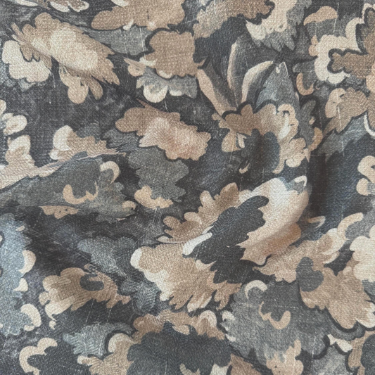 The image is a close-up of a fabric with a floral pattern in shades of brown and gray. The pattern consists of various shades of brown and gray flowers and leaves, creating a visually interesting and textured design.