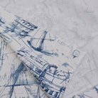 a close-up view of a fabric with a blue and white abstract pattern, including various shapes and lines.