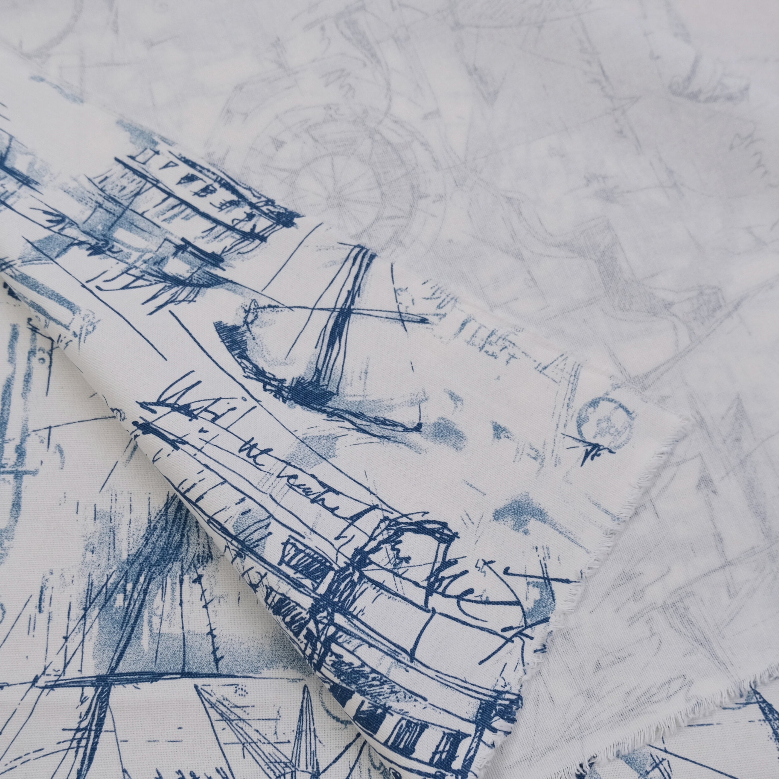 a close-up view of a fabric with a blue and white abstract pattern, including various shapes and lines.