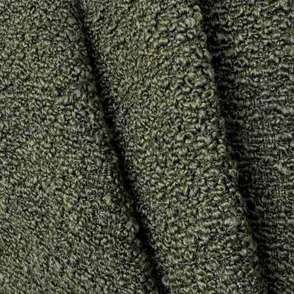 a close-up view of a textured fabric with a dark green or black color. The fabric appears to be made of a tightly woven material, giving it a textured and cozy appearance.