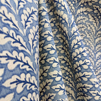 Blue and cream botanical vine fabric draped to show classic floral pattern and texture