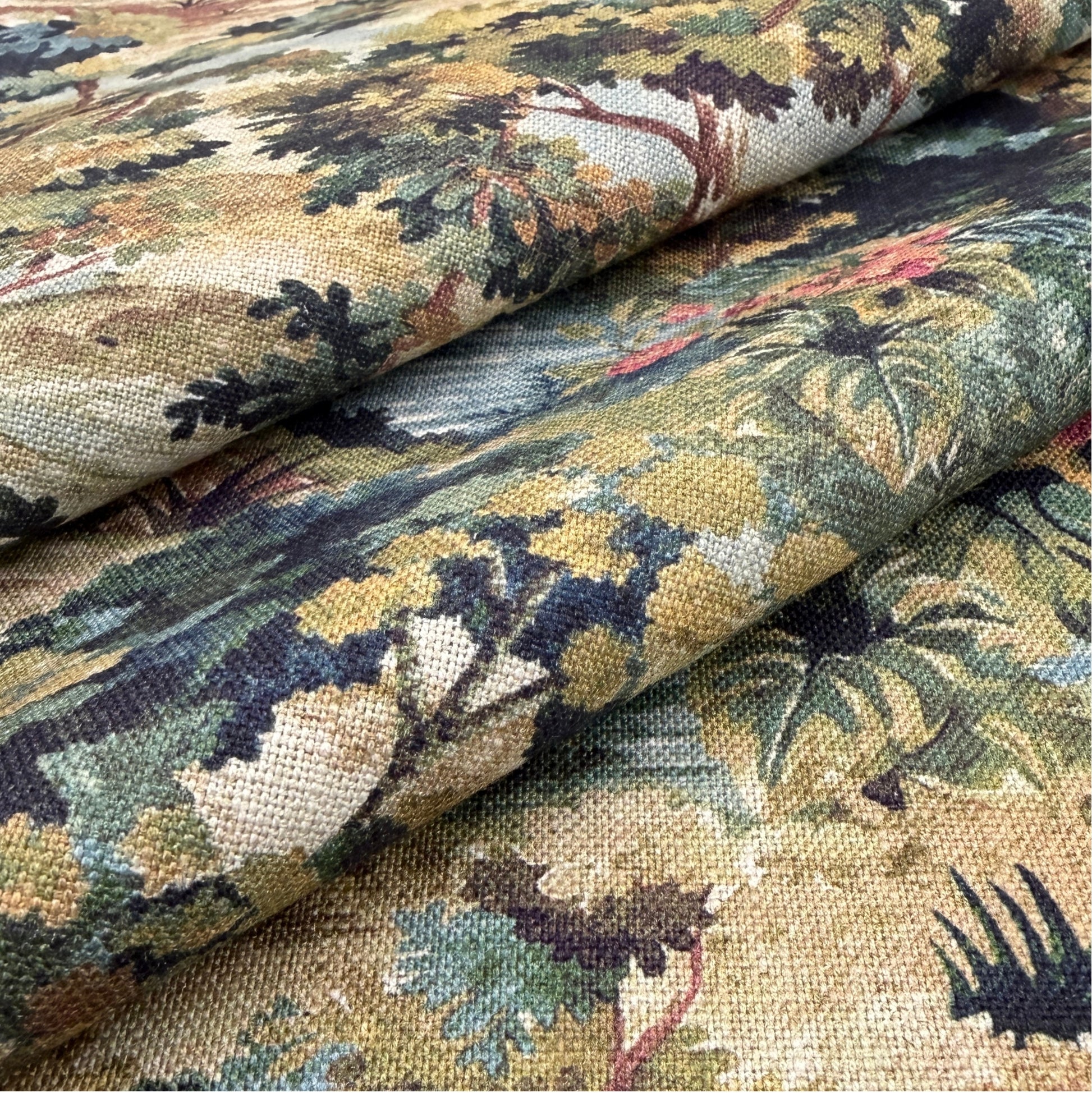 a close-up view of a fabric with a detailed, colorful floral pattern. The fabric appears to be a type of textile, possibly a piece of clothing or a decorative item. The pattern consists of various shades of green, yellow, and brown, creating a vibrant and visually appealing design.