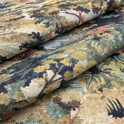 a close-up view of a fabric with a detailed, colorful floral pattern. The fabric appears to be a type of textile, possibly a piece of clothing or a decorative item. The pattern consists of various shades of green, yellow, and brown, creating a vibrant and visually appealing design.