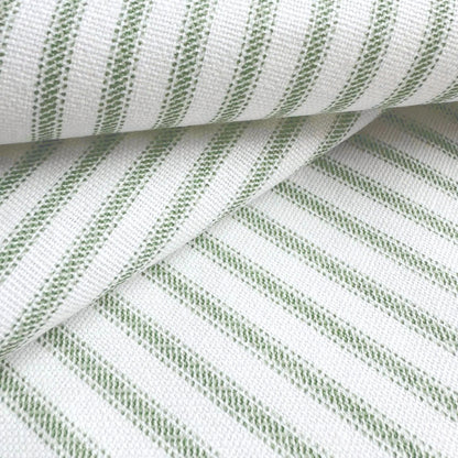 a close-up view of a fabric with a striped pattern in shades of green and white. The fabric appears to be folded or rolled, creating a visually interesting and textured surface.